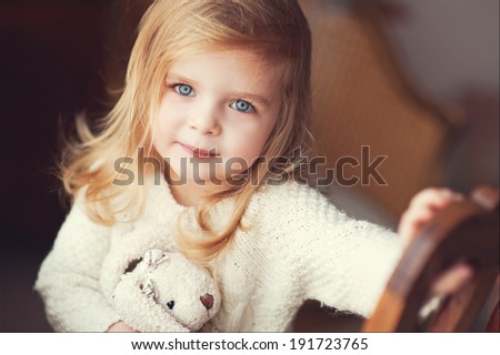 Portrait of cute little girl with bunny in beige tone