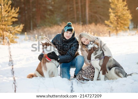 Laughing family and husky dog in winter park