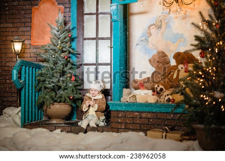 little girl sitting on the doorstep and catches the snow, Christmas themes