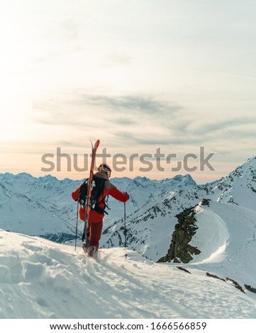 Similar – Image, Stock Photo Skier with red jacket and green backpack in icy snowy landscape walks on lonely ski track on way to mountain in evening light