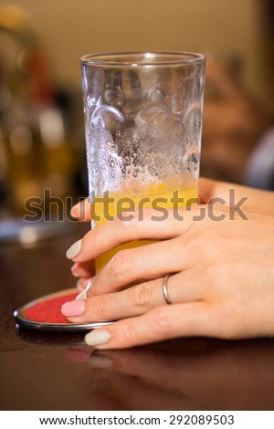 Closeup of hands lady drinking at bar counter.