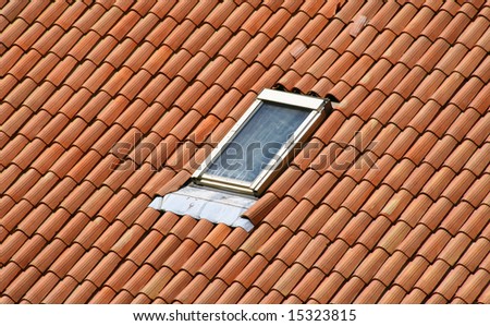 A classic garret on a red tile roof.