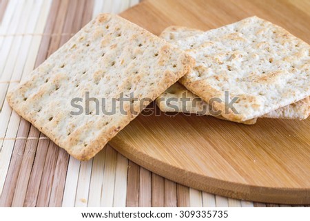 Close up square wheat crackers Snack on wooden mat
