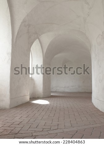 Corridor with arched ceiling and brick floor, open to the courtyard in the Baroque Gothic church.