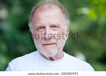 Closeup headshot portrait of happy, confident, cheerful, smiling senior mature man, isolated green trees foliage background. Positive human emotions, facial expressions, feelings, attitude