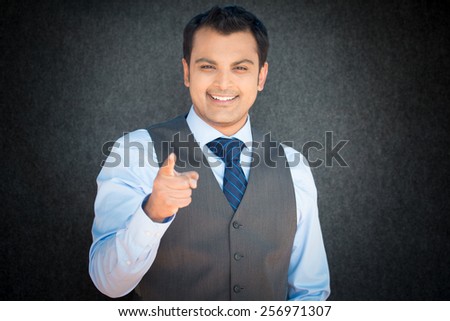 Closeup portrait, smiling handsome, excited, happy man pointing at you camera gesture with finger, isolated gray black background. Positive human emotion facial expression feeling signs symbols