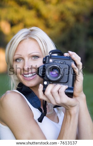 young blond woman holding camera