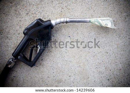 close up of gas pump with money in the nozzle