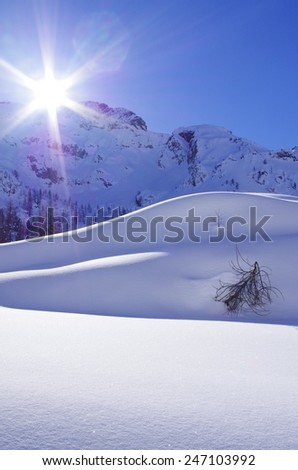 Breathtaking view of a mountain landscape with high mountain, snow, blue sky and clouds.