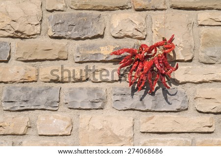 Chillies in drying. Chiles places to dry against the wall of a stone cottage.