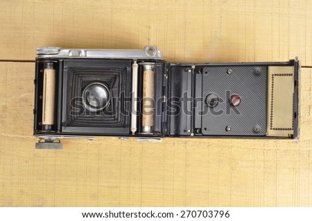 Old film camera on wooden background open