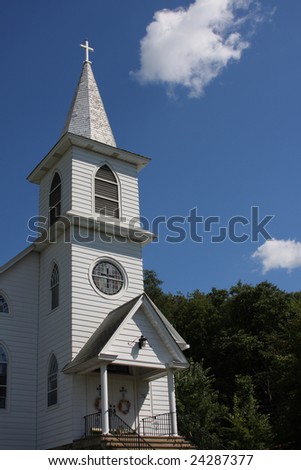 Traditional White community church shot against a blue sky and trees