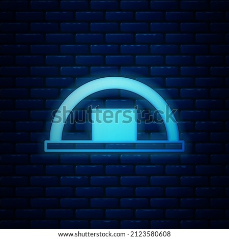 Glowing neon Warehouse icon isolated on brick wall background.  Vector