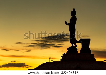 Silhouette big buddha statue in sunset background.