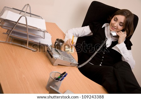 Businesswoman calling by phone at office