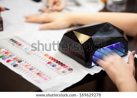 Woman\'s hands with UV lamps at nail studio