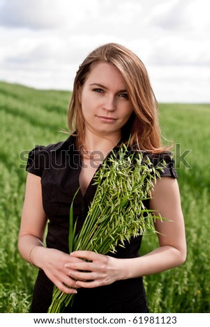 Woman in black cloth in sunlight holding a lot of plants in her hand