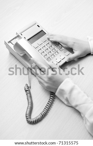 Woman\'s hands with telephone in the office