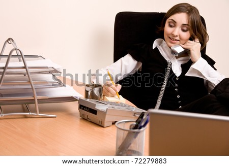 Picture of businesswoman calling by phone at office