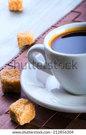 Cup of black coffee with a few cubes of cane sugar