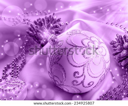 Christmas decoration. Christmas ball, pine cones, glittery jewels on white satin.Purple background.