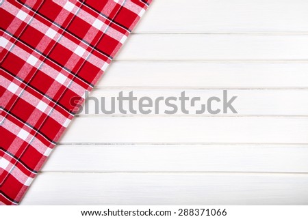 Top view of checkered kitchen towels on wooden table. Free space for your creative information
