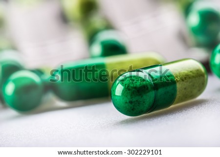 Pills. Tablets. Capsule. Heap of pills. Medical background. Close-up of pile of yellow green  tablets - capsule. Pills and tablets.Green background.