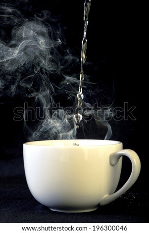 Water Poured into Coffee Cup with Steam on Black Background