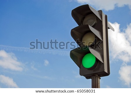 Green color on the traffic light with a beautiful blue sky in background