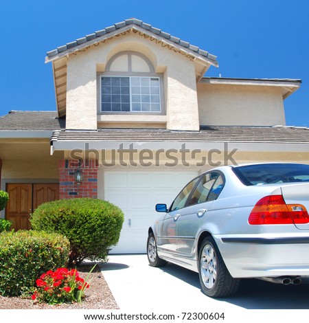 New American dream home with a beautiful blue sky in background and brand new car parked outside.
