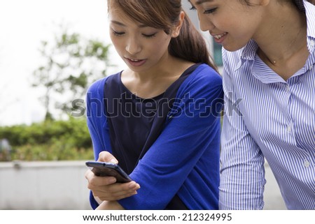 Women talk while watching the smart phone
