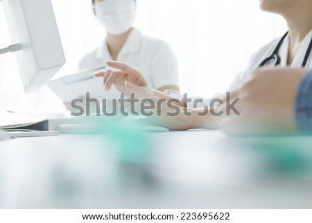 Doctor to explain to the nurse while pointing at computer