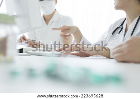 Doctor to explain to the nurse while pointing at computer