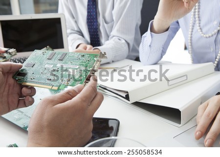People to discussions the circuit board while watching the documents