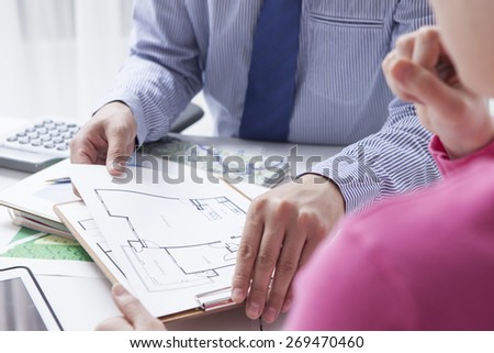 Woman in real-estate agency talking to construction planner