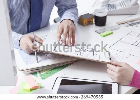 Woman in real-estate agency talking to construction planner