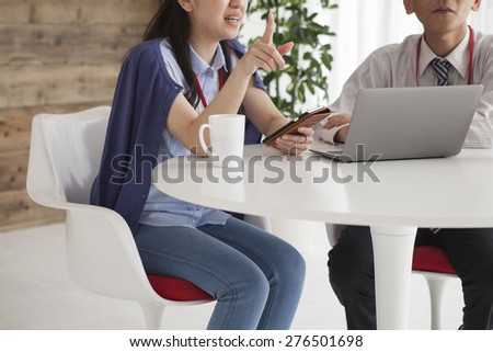 Business meeting in office, businesspeople working with laptop, couple of beautiful colleagues smiling having a work, two partners having good idea smiling together, teamwork with businesspeople