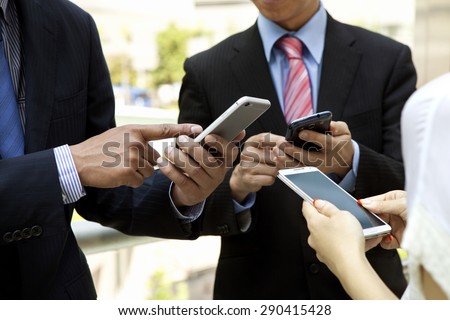 Group of business people using smart phones.