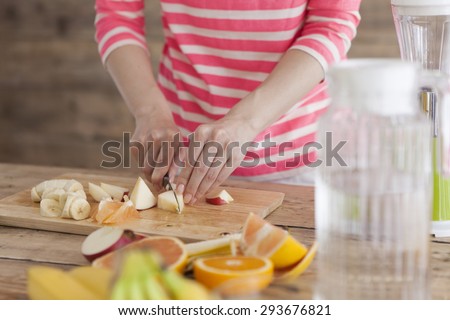 Young woman preparing cutting fruit in the kitchen at home