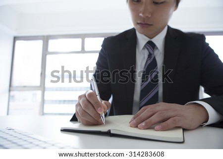 Young man to write a note to the document