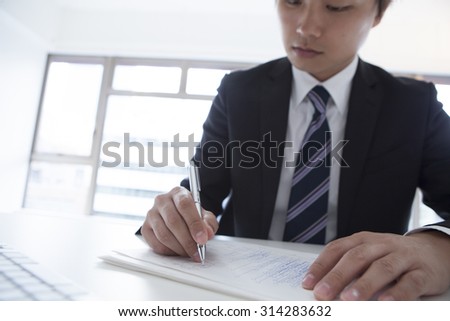 Young male employees to write a note to the document