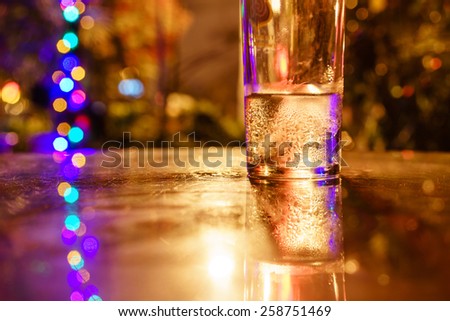 A glass of cold water on table at night with bokeh
