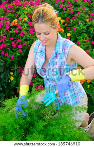 Pretty young woman working in a flower garden, natural model, natural lighting