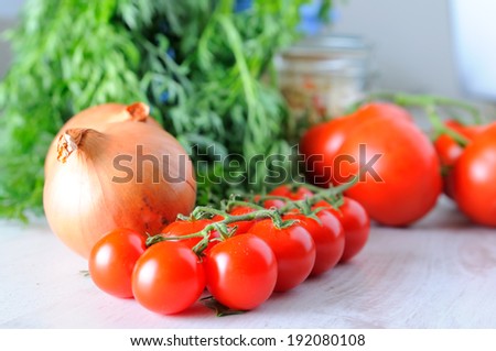 Vegetable groceries on the wooden kitchen table - tomatoes, cherry tomatoes and lettuce - selective focus
