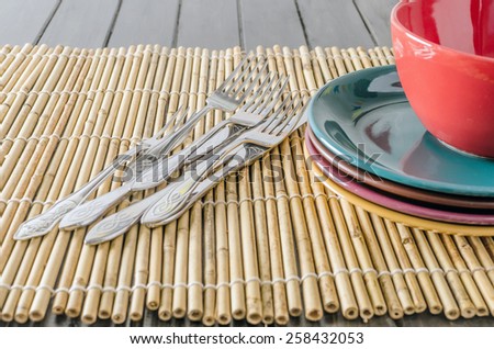 plate, fork and spoon on a bamboo mat