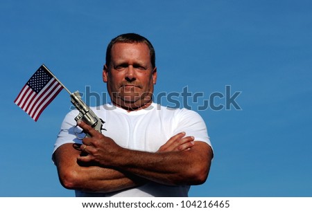 Muscular White Man Holding An American Flag And Gun, symbolizing our constitutional right to own and bear arms