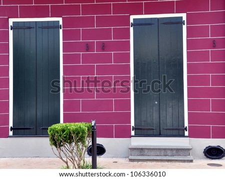 Magenta Cinder Block Wall With Black Shuttered Doors In New Orleans French Quarter