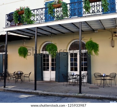 A Sidewalk Cafe And Balcony In The New Orleans French Quarter