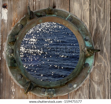 Sparkling ocean water seen through a rustic old porthole.