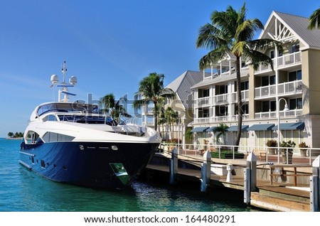 Luxurious Yacht Docked In Front Of Tropical Waterfront Condominiums